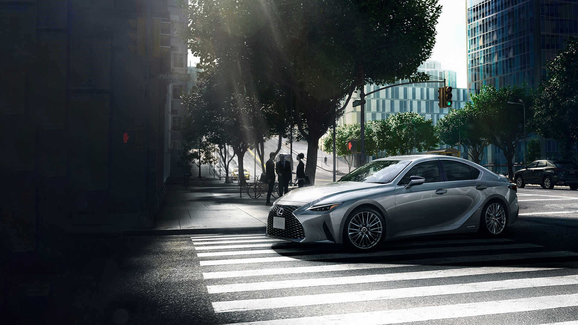 Silver Lexus IS being driven in a city.