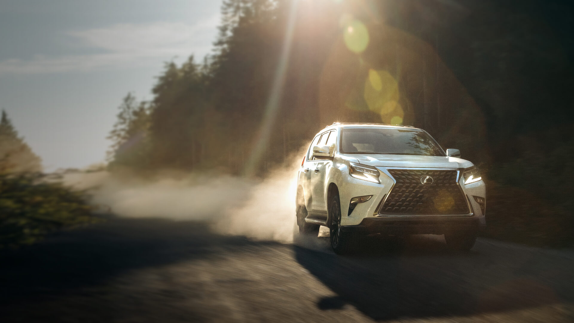 White Lexus GX being driven on a dirt road.